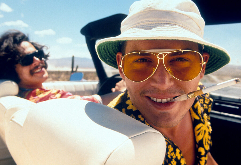 Benicio Del Toro and Johnny Depp in convertible together in a scene from the film 'Fear And Loathing In Las Vegas', 1998. (Photo by Universal/Getty Images)